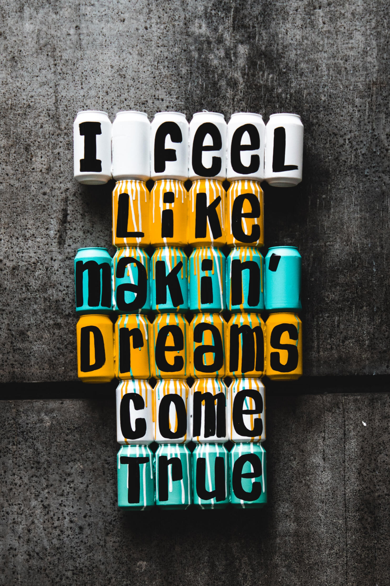 Painted tins spelling out the words "I feel like making dreams come true"